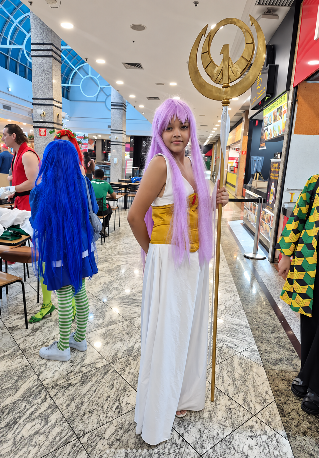 Cosplayer com traje branco e cabelos lilás em uma edição da Geek Day