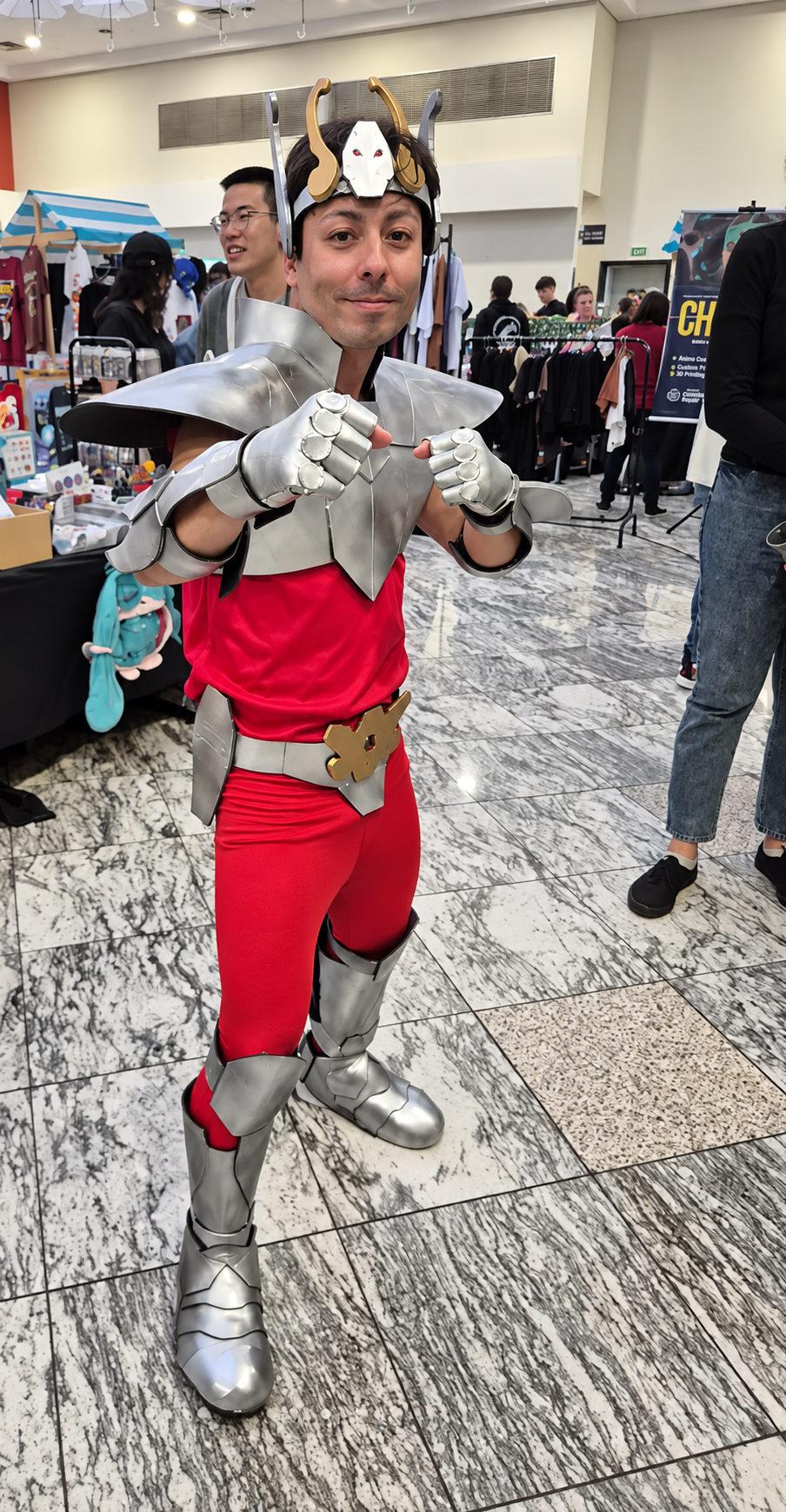 Cosplayer com armadura prateada e traje vermelho