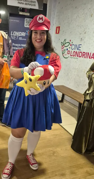 Cosplayer com vestido azul e acessórios vermelhos