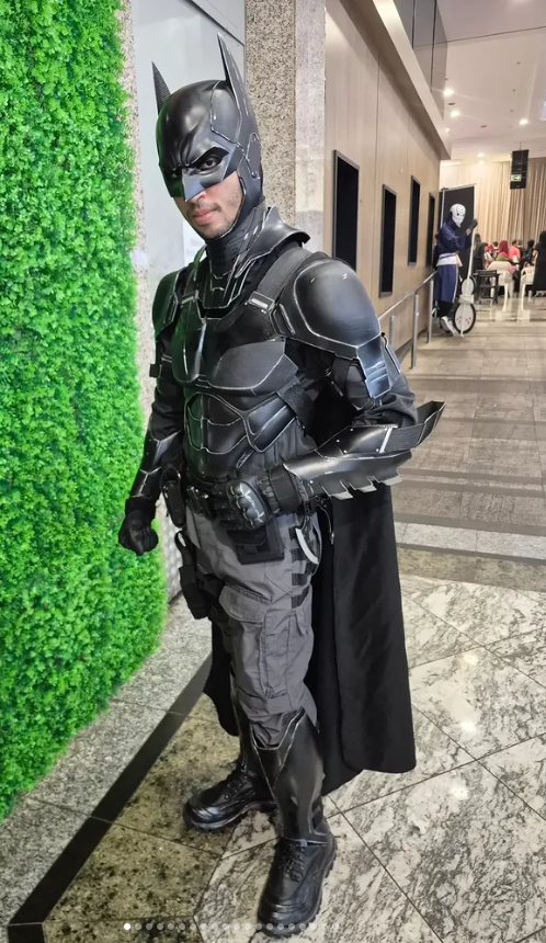 Cosplayer com armadura escura em ambiente de evento